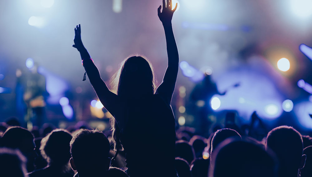 Woman on someone's shoulders at a concert