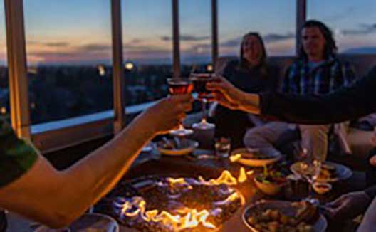 Group cheersing drinks at Sky Shed at sunset