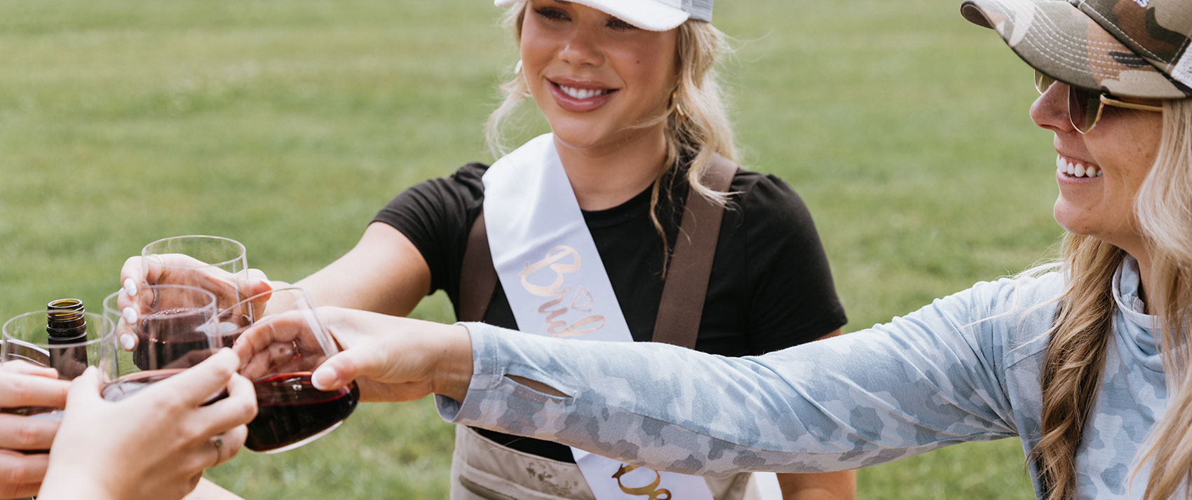 women in flyfishing gear drinking wine